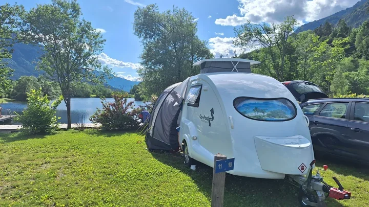 A Go-Pod beside a lake with hills in the distance