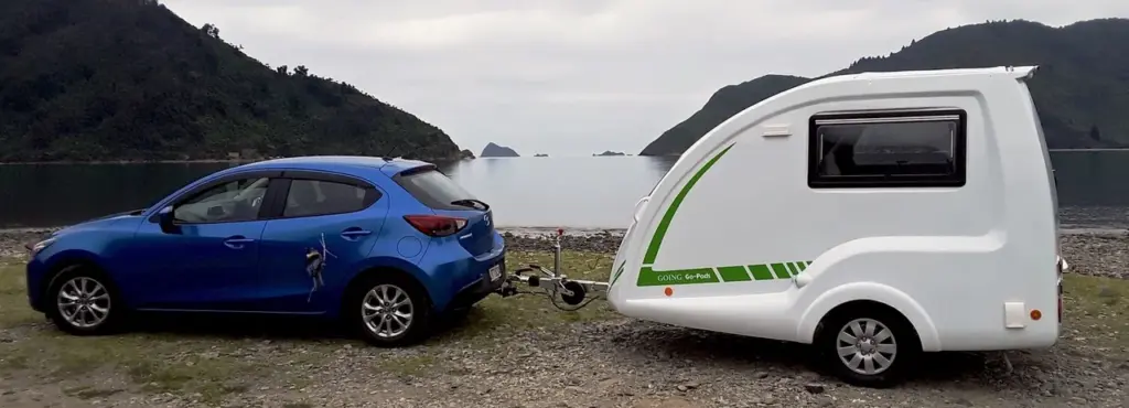 Blue car and Go-Pod parked beside a lake