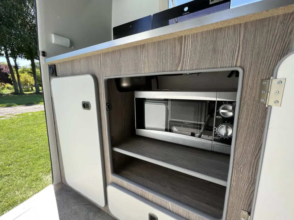 Microwave inside the open kitchen cupboard