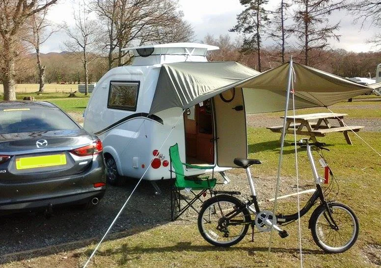 Go-Pod campsite setup with a canopy and bicycle