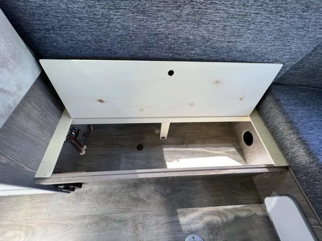 Open storage compartment beneath a lounge seat