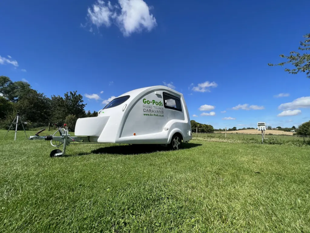White Go-Pod parked on grass beneath a blue sky